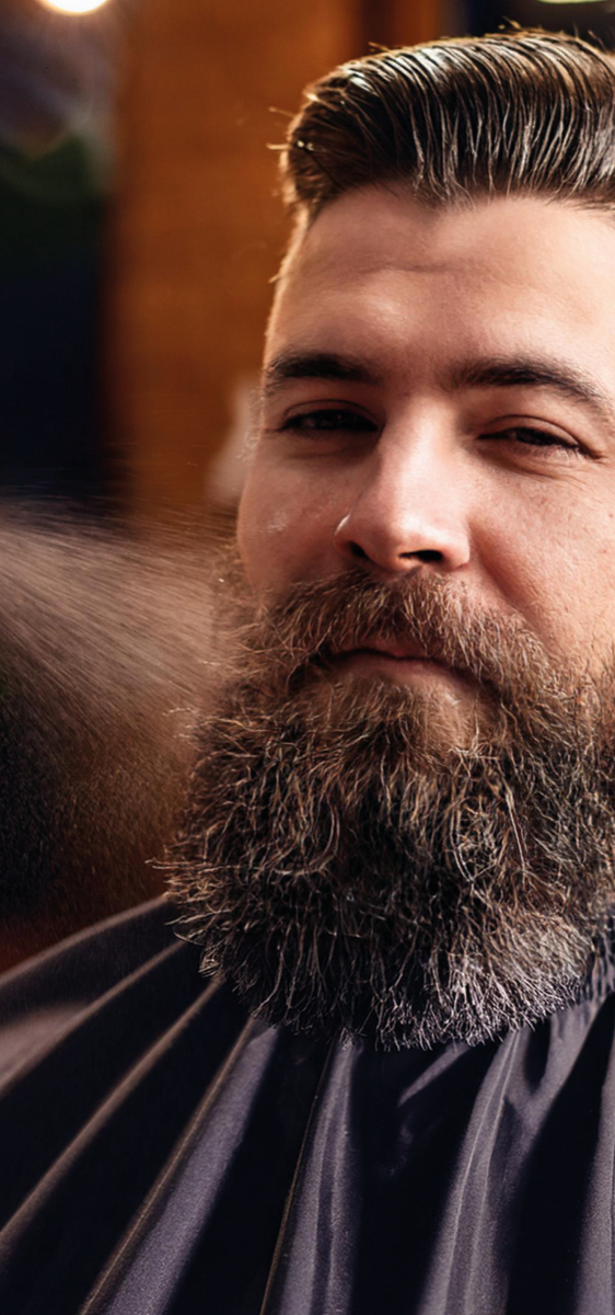 volto di un uomo, con barba lunga e a lato uno spruzzo dello spray